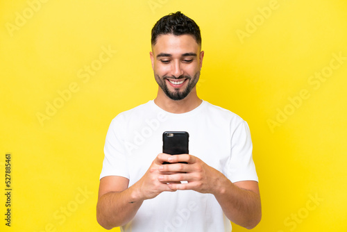 Young Arab handsome man isolated on yellow background sending a message or email with the mobile