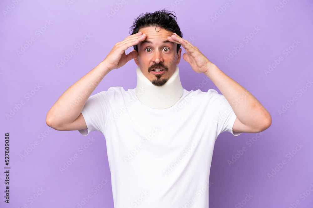 Young caucasian man wearing neck brace isolated on purple background with surprise expression Young caucasian man wearing neck brace isolated on purple background with surprise expression