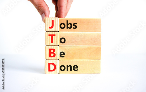 JTBD jobs to be done symbol. Concept words JTBD jobs to be done on wooden blocks on beautiful white background. Businessman hand. Business and JTBD jobs to be done concept. Copy space. photo