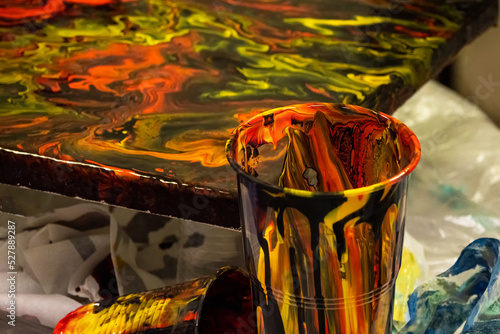 Mess on the artists desk. Liquid colorful dark resin art abstract background. Epoxy resin art painting space. photo