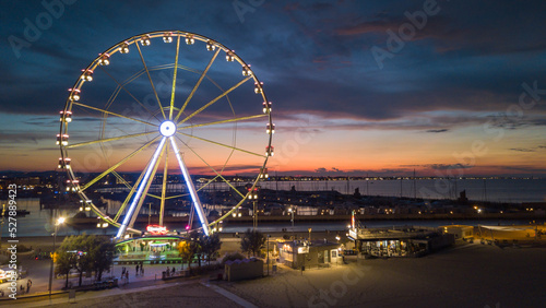 Italy, September 2022: view of the ferris wheel of Rimini with all the colored lights near the beach of the Riviera Romagnola