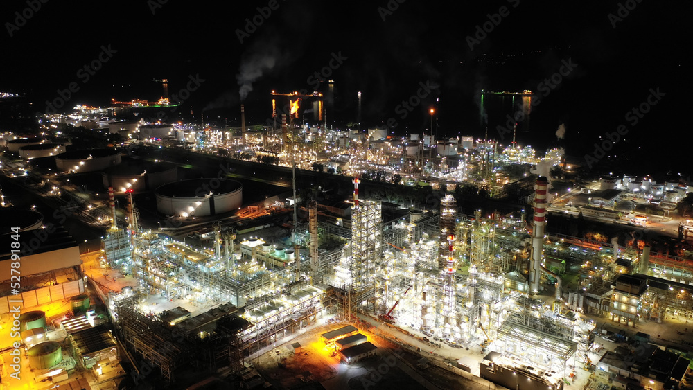 Aerial drone night shot of illuminated crude oil refinery in Mediterranean seaside destination