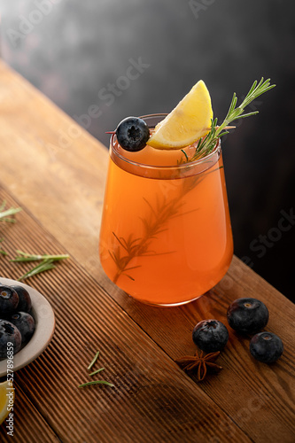 Bourbon cocktail glass with rosemary and lemon slice, old fashion cocktai ldrink, moody background photo