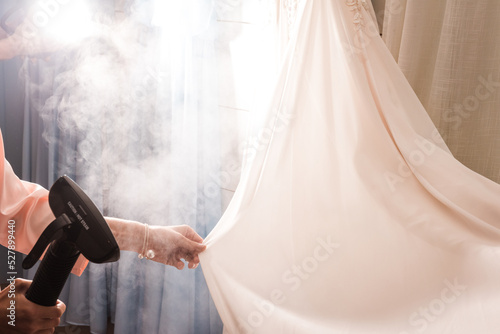 Fotografi Steaming of bridal gown before wedding