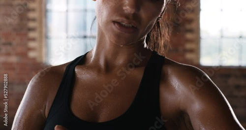 Hands, gym and fitness of a woman in sweat after intense workout taking off hand bandages. Fit, sweaty and young female athletic boxer or fighter done with sports training or exercise in a studio.