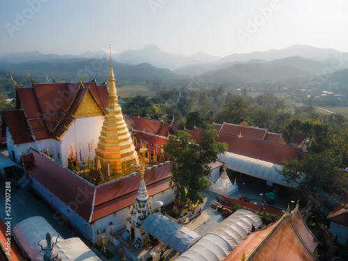 Aerial view of beautiful golden pagoda in Wat Phra That Cho Hae with nature landscape background at Phrae, Thailand.