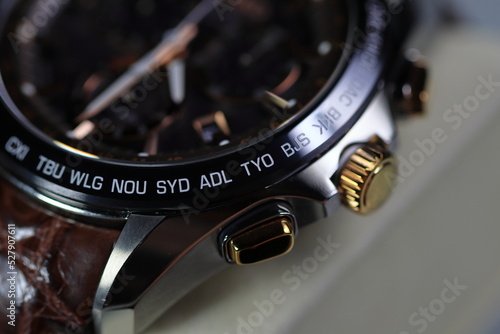 close up shallow focus Time zone cities code on luxury world time watch bezel, SYD Sydney, ADL Adelaide, NEU Neumea, TYO Tokyo. photo