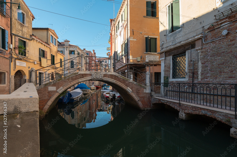 Vue typique et touristiques des canaux de Venise en Italie avec le pont qui se refletent dans l'eau en effet miroir