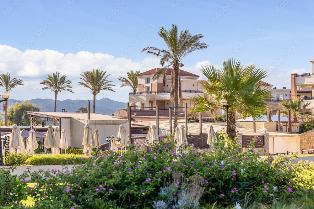 Modern buildings on the island of Crete, Greece. Hotel area and palm trees. Luxury tropical apartment resort complex. High quality photo