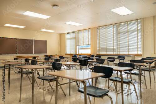 Example of an empty nondescript US High School Classroom with desks  Window and black board.