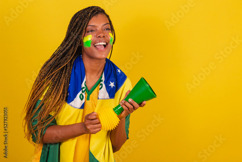 black woman young brazilian soccer fan. using the horn, making noise, Partying championship.