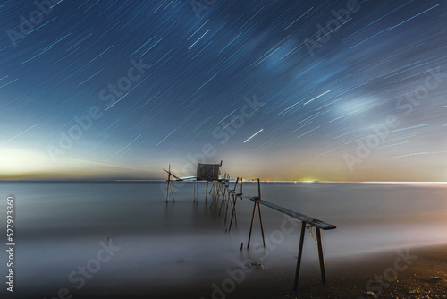 seascape with a longexposured milky way and fishery at night photo