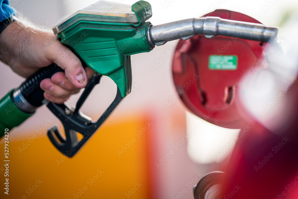 Man refueling his car with gasoline pump. To simulate the high costs of fuel , pollution and energy consumption- Man refueling his car with gasoline pump. To simulate the high costs of fuel , pollution and energy consumption-