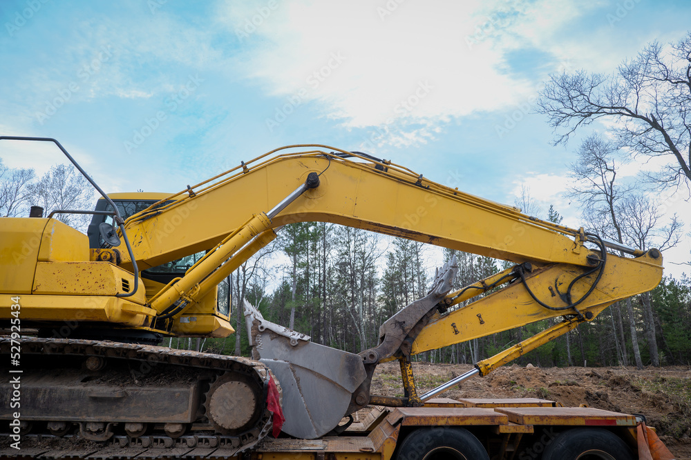 Boom and Bucket of Skid Steer Excavator Loader on a flat bed trailer.