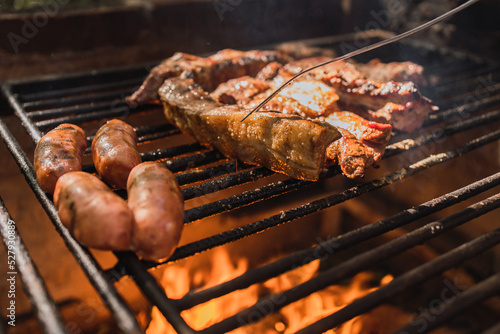 Crop person grilling delicious meat pieces above fire