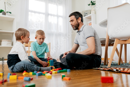 Father talking to sons on floor with module blocks