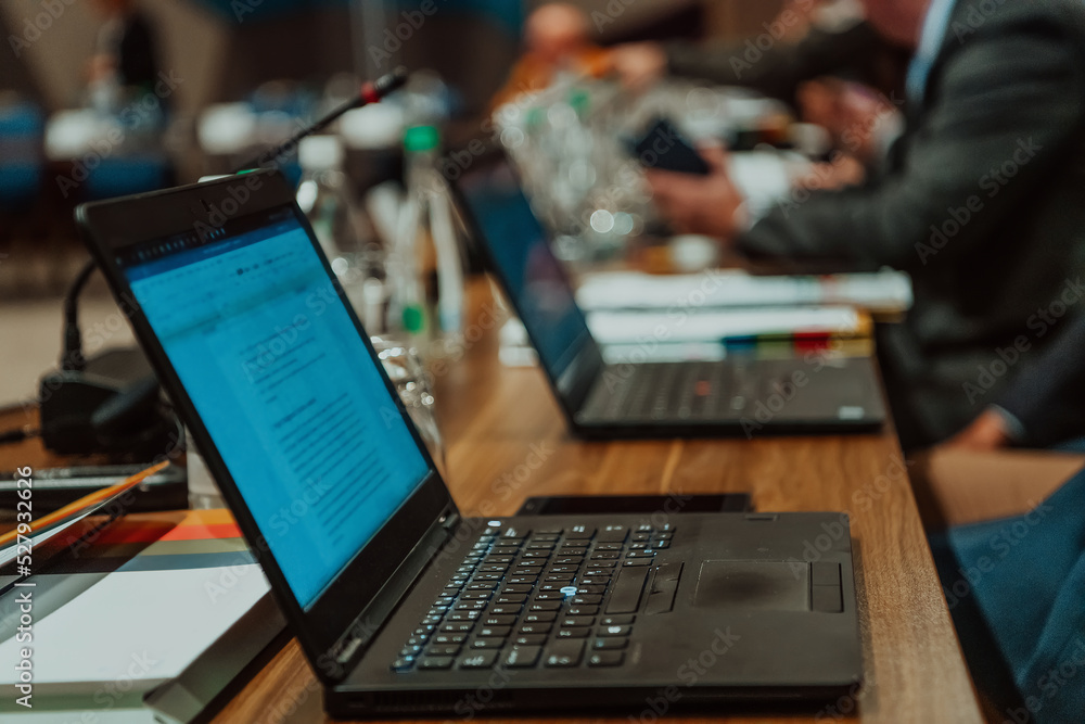 Photo of a laptop on a table in a modern seminar hall. Selective focus Photo of a laptop on a table in a modern seminar hall. Selective focus
