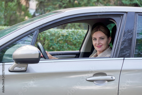 Attractive woman behind wheel of her car, outside view. © Cavan