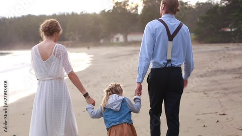 Family walking on beach after elopement in California photo