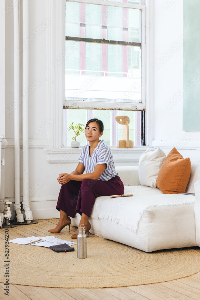 Portrait of confident young businesswoman sitting on sofa Portrait of confident young businesswoman sitting on sofa
