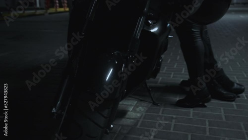 Young couple kissing on a motorcycle in underground parking garage