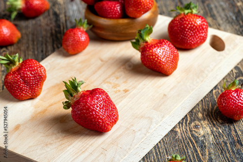 Ripe red strawberries lying on a wooden tray