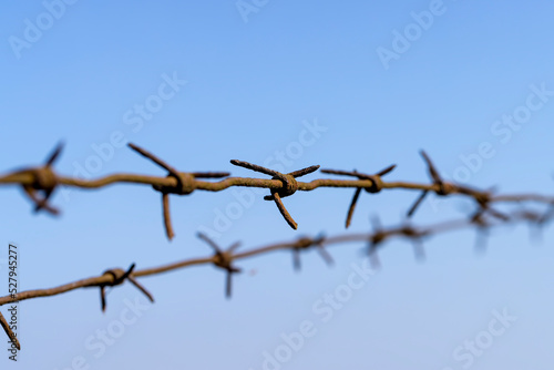 Old barbed wire against the blue sky