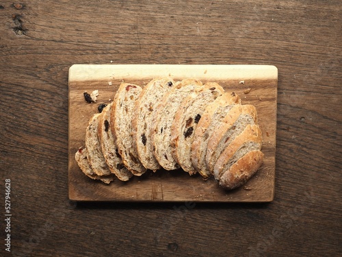 sliced whole wheat bread with cranberry and raisin on wooden cutting board