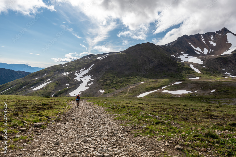Fototapeta premium Man hiking through large outdoor open mountain area in northern Canada.