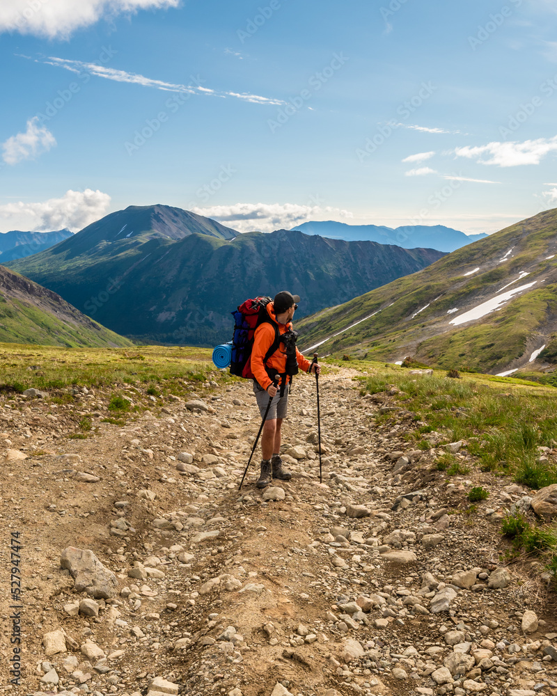 Fototapeta premium Man hiking in northern Canada, Yukon Territory during summertime. 