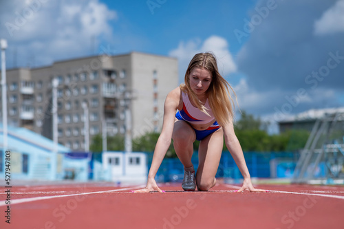 Female runner in the stadium is ready to race. © Михаил Решетников