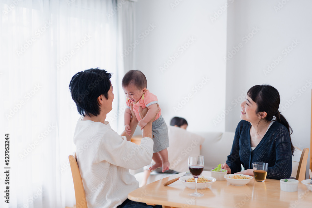 赤ちゃんに高い高いをするお父さん
