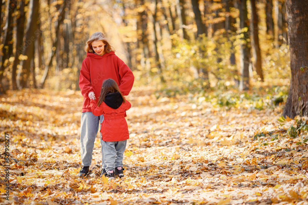Mother and daughter walking and playing in autumn forest Mother and daughter walking and playing in autumn forest
