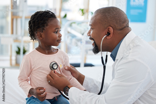 Kids doctor, stethoscope and consulting hospital worker in medical help, insurance exam or lung test. Happy smile or pediatrician healthcare employee with girl patient in children medicine cardiology photo