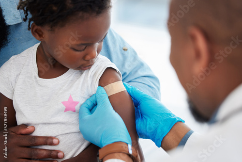 Foto Child, healthcare vaccine and doctor with plaster for skin protection after injection appointment