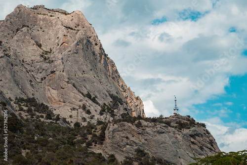 Large rock with green forest around.