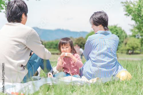 公園でピクニックする親子・家族・ファミリー  © buritora