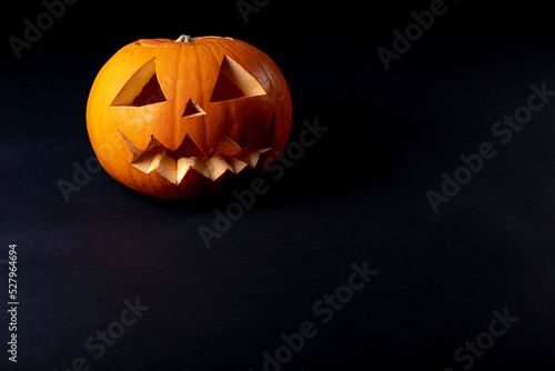 Composition of halloween jack o lantern and copy space on black background
