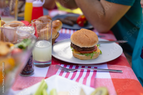 Close-up of burger served in plate by drinks on table