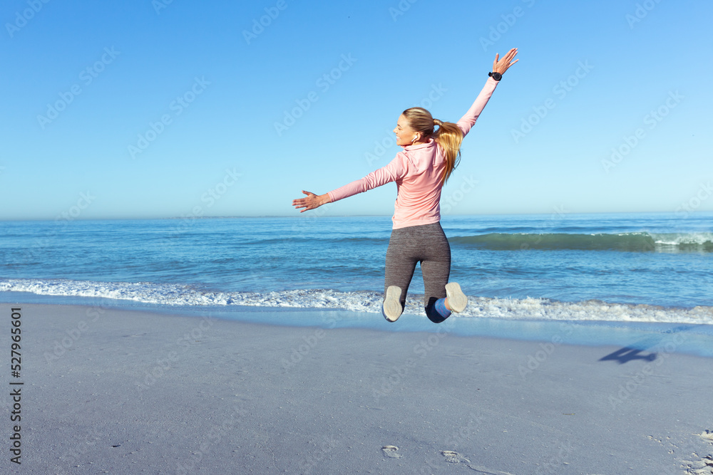 Caucasian woman spending time seaside wearing sportswear