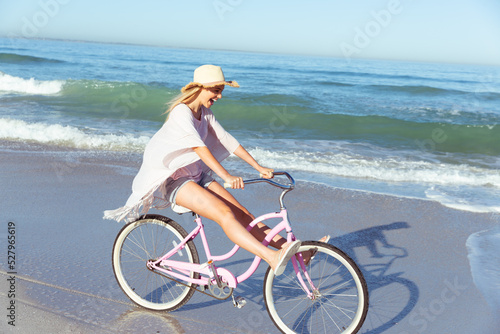 Caucasian woman spending time seaside and riding a bike