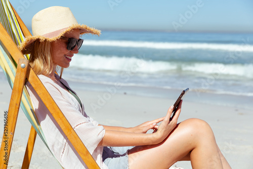 Caucasian woman using a digital tablet seaside