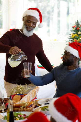 Senior african american man pouring juice and african american man holding glass