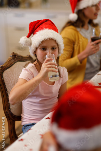 Caucasian girl sitting at table and drinking juice