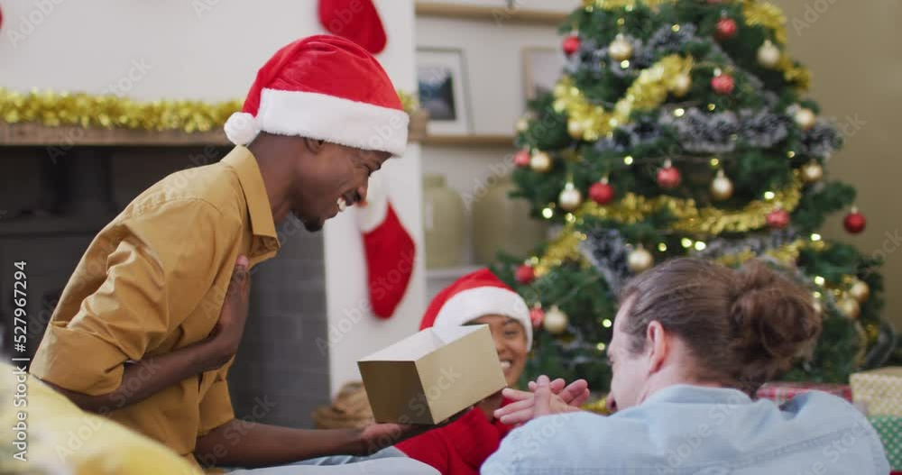 Happy diverse group of friends sharing with presents at christmas time Happy diverse group of friends sharing with presents at christmas time
