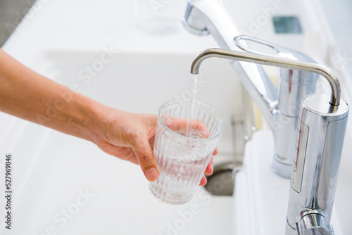 浄水器の水をグラスに満たす主婦の手元