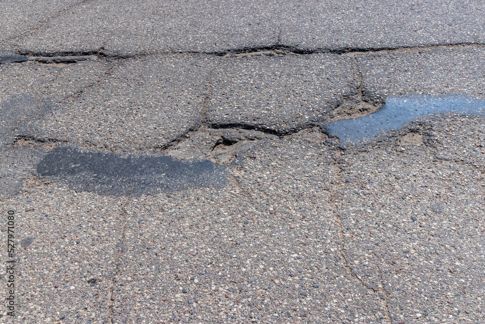 Obraz premium An old paved road with a lot of holes and damage