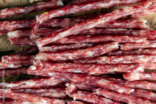 thin dried meat sausages with spices , close up