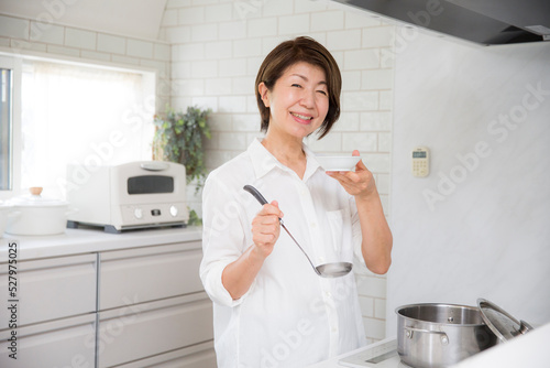 調理風景、味見をするミドルの日本人女性 photo