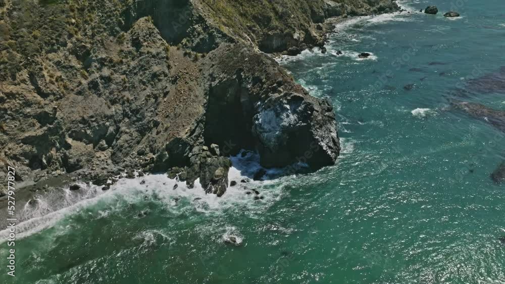 Aerial top view of ocean blue waves break on a coastline Aerial top view of ocean blue waves break on a coastline